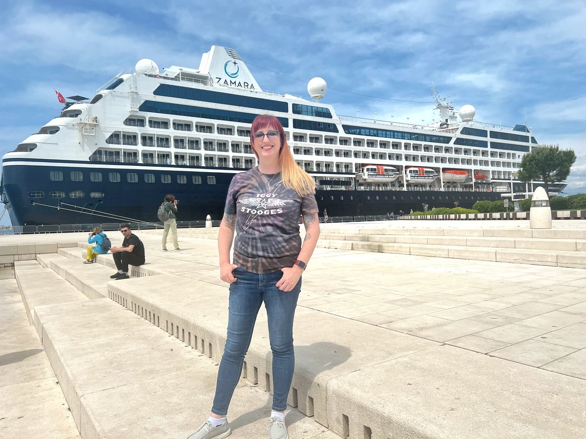 Adrianne standing on the Sea Organ steps in Zadar with the Azamara Onward ship in the background 